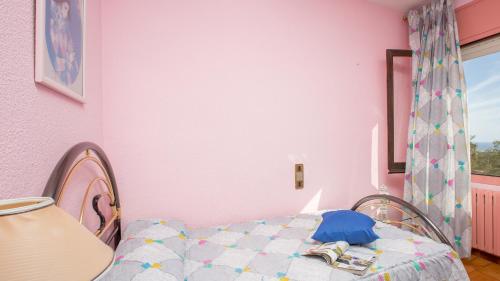 Habitación de color rosa con cama y ventana en 2 Carva - Blanes, en Blanes