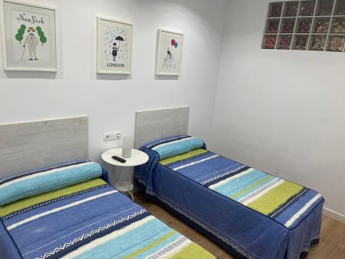 two beds sitting next to each other in a bedroom at ANARAL-Casco Viejo Gijon-AUTOCHECK 24h in Gijón