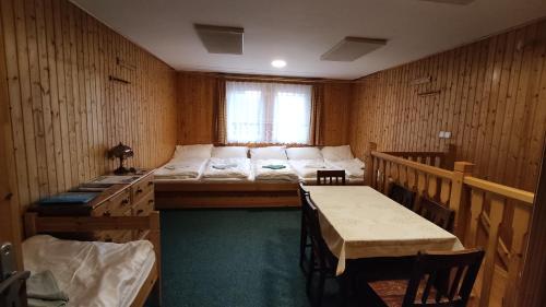 a room with a bed and a table and chairs at Penzion apartmány Aninka in Mariánská