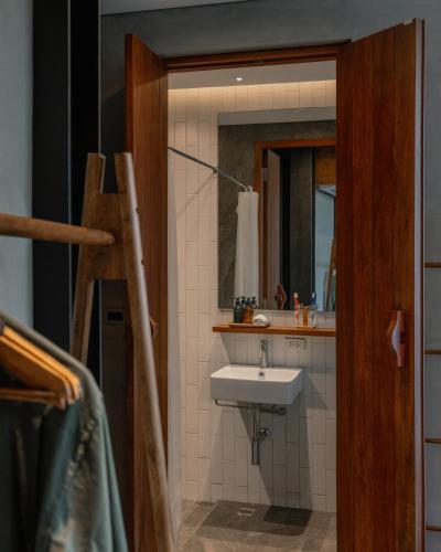a bathroom with a sink and a mirror at Tamni in Bangkok