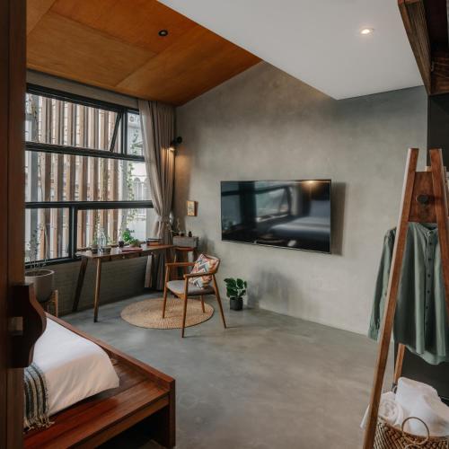 a bedroom with a bed and a tv on a wall at Tamni in Bangkok