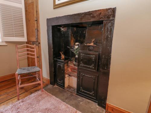 an old wood stove in a room with a chair at But `n' Ben in Whitby