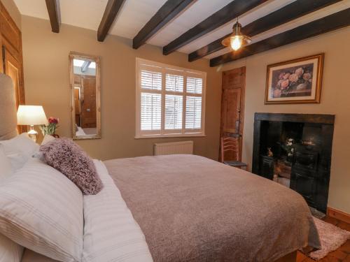 a bedroom with a large bed and a fireplace at But `n' Ben in Whitby