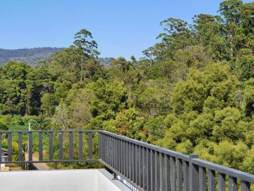 a balcony with a view of a forest at The Edge Luxury Apartment in Nuwara Eliya