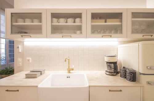 a kitchen with a sink and a white refrigerator at MARITXU'S HOME in Donostia-San Sebastián