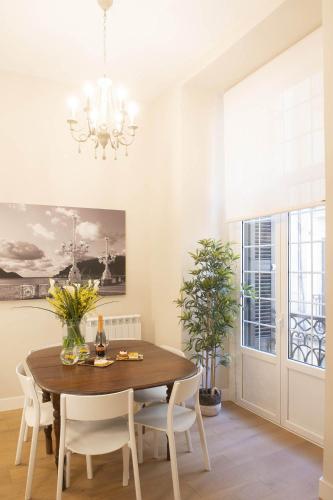 a dining room with a table and chairs and a chandelier at MARITXU'S HOME in Donostia-San Sebastián
