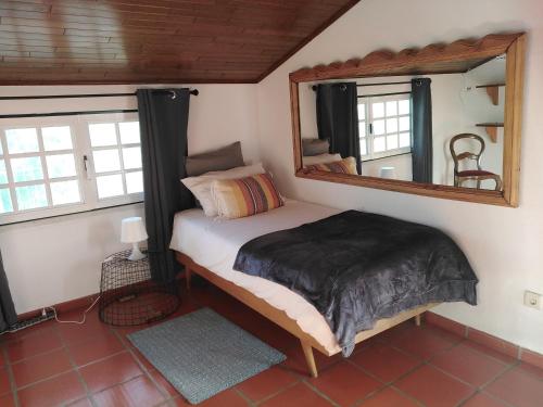 Dormitorio pequeño con cama y espejo en MIX inn en Vendas Novas
