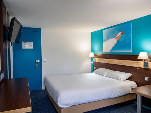 a hotel room with a bed and a tv at Contact Hotel Restaurant La Chaumière entre Orgeval et Flins A13 sortie 8 in Les Mureaux