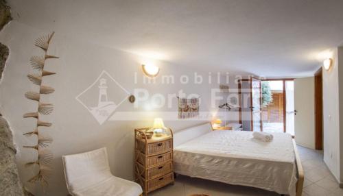 a bedroom with a bed and a table and a chair at 13 PN - Vecchio Marino villino con tre camere in Palau