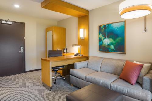 a living room with a couch and a desk at Hyatt Place Hampton Convention Center in Hampton