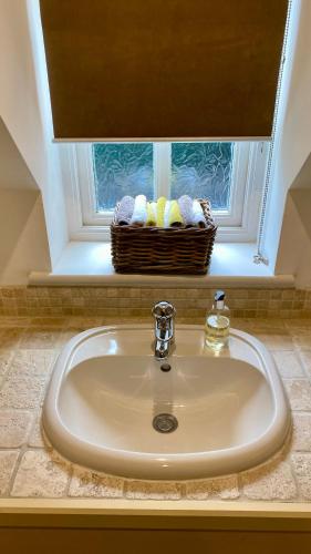 a sink in a bathroom with a basket of towels at Keepers Lodge in Swithland