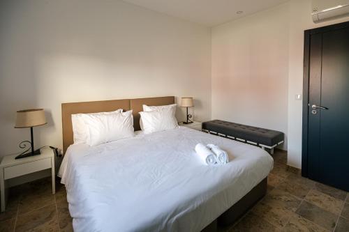 a bedroom with a large bed with white sheets at QR Casas de Campo in Vale de Santarém