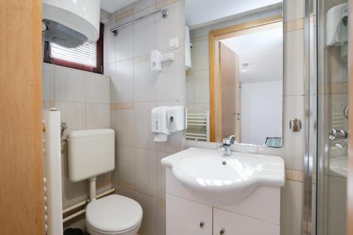 a white bathroom with a sink and a toilet at Hotel Vamos Sarajevo, b&b in Sarajevo
