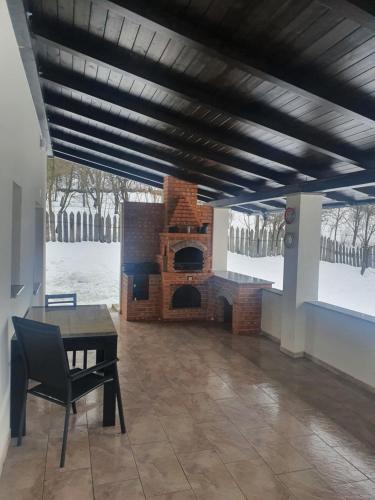 a living room with a brick fireplace and a table at Casa Danci Centru in Borşa