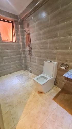 a bathroom with a white toilet in a room at LA BEILA HOTEL MERU in Meru