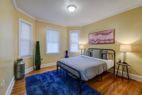1 dormitorio con 1 cama con alfombra azul y ventanas en Spacious apartments near Ashmont - Evonify Stays, en Boston