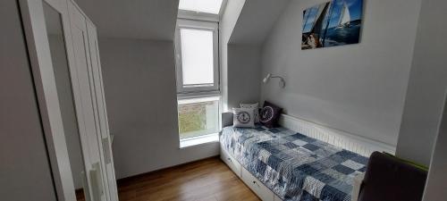 a small bedroom with a bed and two windows at Nadmorski Klif in Mechelinki