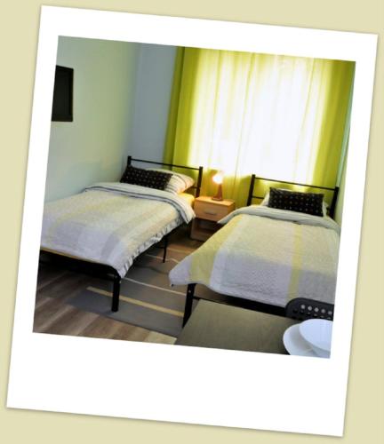 a room with two beds and a window at Apartament w Alei Fontann. in Szczecin