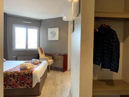 a bedroom with a bed and a desk and a window at Hôtel Causse Comtal Rodez, The Originals Relais in Gages-le-Haut