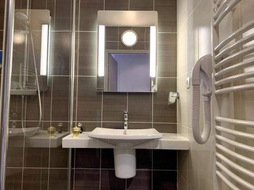 a bathroom with a sink and a mirror at Hôtel Causse Comtal Rodez, The Originals Relais in Gages-le-Haut