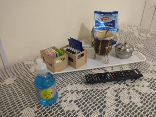 a bottle of water and a remote control on a bed at Departamentos Araoz in Salta