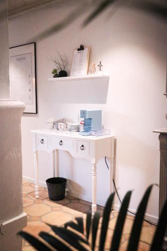 a white desk in a room with a shelf at SOEDER Countryhouse & Kitchen in Båstad