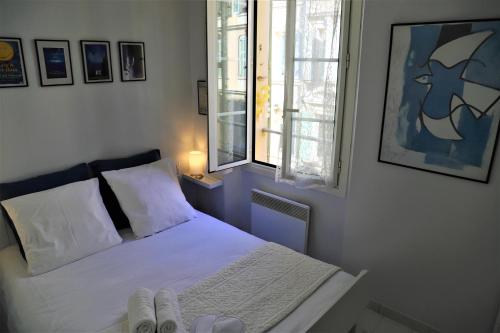 1 dormitorio con 1 cama con sábanas blancas y ventana en Hoche Cannes Centre "Palais - Croisette - Beach", en Cannes