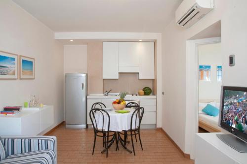 cocina y comedor con mesa y sillas en Aris Residence, en Riccione