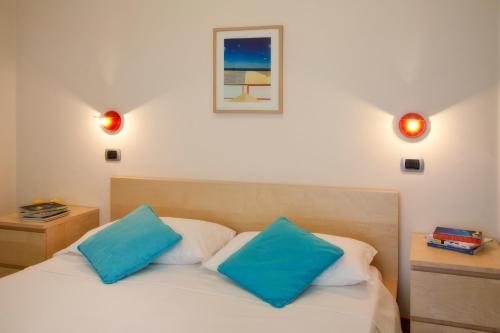 1 dormitorio con 1 cama con 2 almohadas azules en Aris Residence, en Riccione