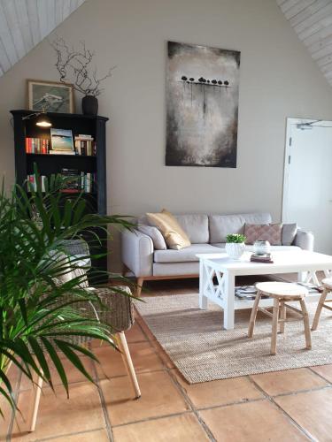 a living room with a couch and a table at SOEDER Countryhouse & Kitchen in Båstad