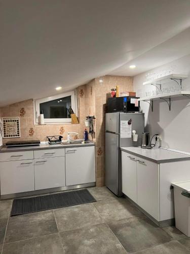 a kitchen with white cabinets and a refrigerator at apartma "happy Scotts" in Starše