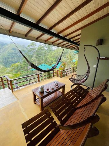 a room with a hammock and a table and a balcony at Zion View Ella Green Retreat in Ella