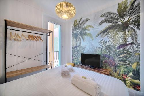 um quarto com uma grande cama branca e toalhas em IMMOGROOM - Refurbished - Suquet - Sea view em Cannes