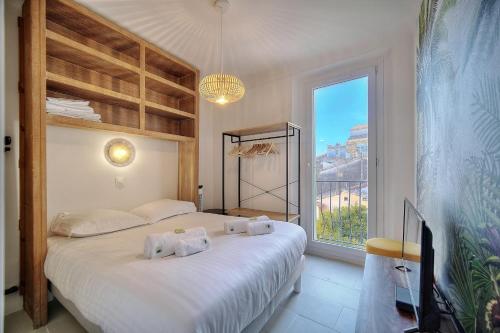 um quarto com uma cama e uma grande janela em IMMOGROOM - Refurbished - Suquet - Sea view em Cannes