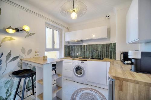 une cuisine avec une machine à laver et une table dans l'établissement IMMOGROOM - Refurbished - Suquet - Sea view, à Cannes