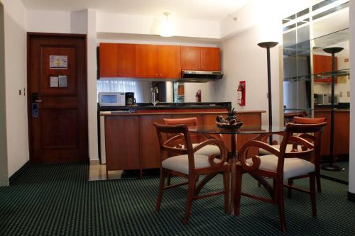 a kitchen with a table and chairs in a room at HOTEL ALTAMIRA SUITES in Caracas