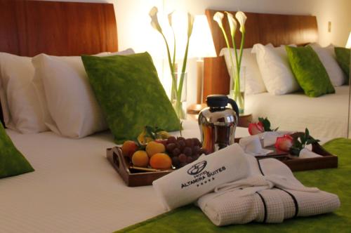 a hotel room with a tray of fruit on a bed at HOTEL ALTAMIRA SUITES in Caracas