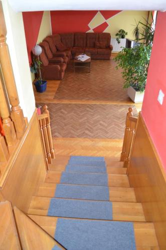 a living room with a staircase with a blue carpet at Smeštaj - sobe MARVEL in Niš