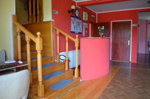 a living room with a staircase and a red wall at Smeštaj - sobe MARVEL in Niš