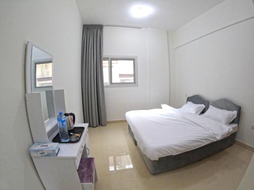 1 dormitorio con cama, mesa y espejo en Karama Star Residence (Home Stay), en Dubái