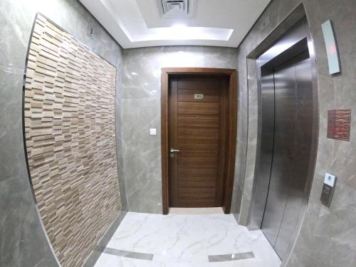 korytarz z drewnianymi drzwiami w pokoju w obiekcie Karama Star Residence (Home Stay) w Dubaju