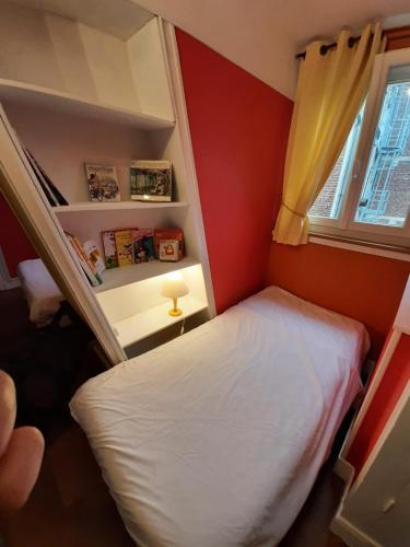 a small room with a bed and a window at Hotel du Cygne in Beauvais