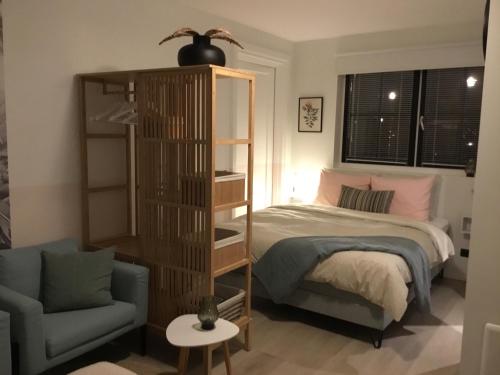 a bedroom with a bed and a book shelf and a chair at Vakantiehuisje het kiekje in Bergen op Zoom