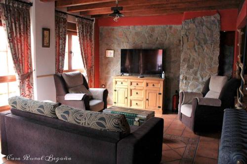 uma sala de estar com um sofá e uma televisão de ecrã plano em Casa Begoña em Igüeña