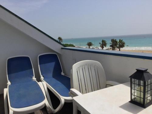a balcony with chairs and a table and the beach at Leme Bedje GST84 3 bedroom apt with Panaramic views in Santa Maria