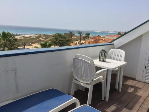 a balcony with a table and chairs and the ocean at Leme Bedje GST84 3 bedroom apt with Panaramic views in Santa Maria