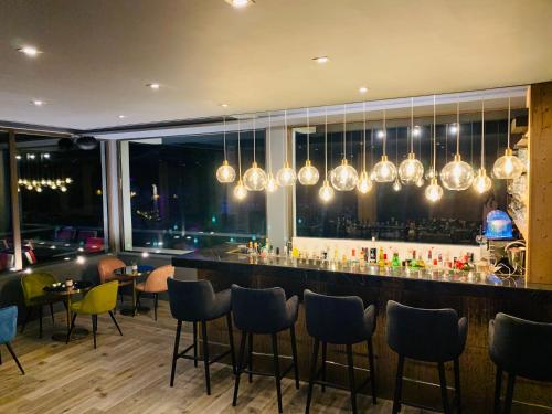 a bar in a restaurant with chairs and lights at Hotel Le Panorama in Le Mont-Dore