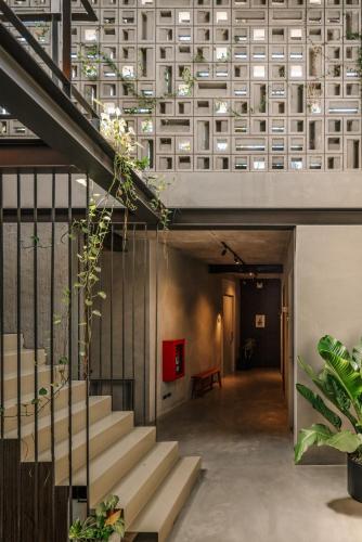 a hallway with stairs in a building with plants at Tamni in Bangkok