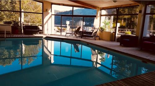 a swimming pool in a house with a view of the mountains at Hotel Le Panorama in Le Mont-Dore
