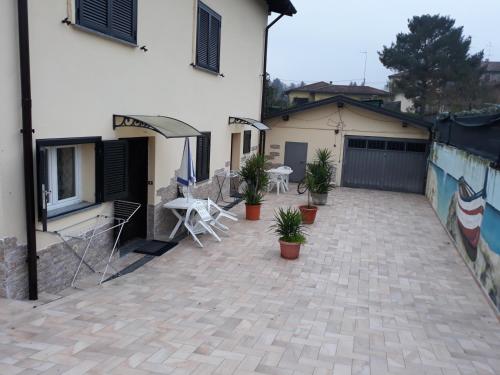 un patio exterior de una casa con sillas y una valla en villa verde bed and breakfast, en Uggiate
